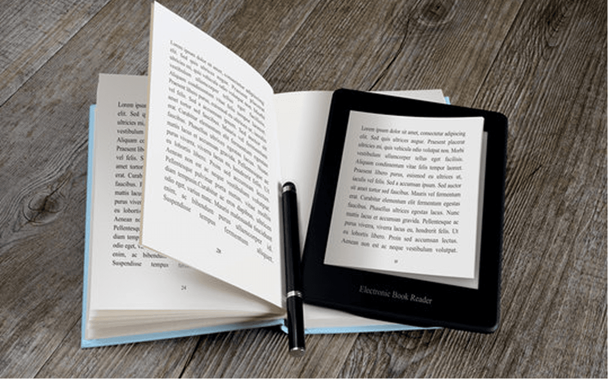 Open print book and electronic book reader side by side on a wooden desk